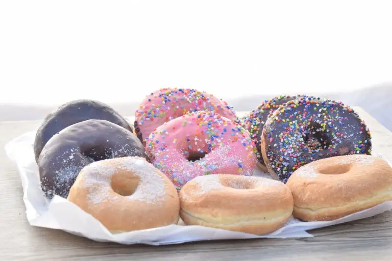 des donuts de différentes couleurs, posés sur une table. L'impact des kilos émotionnels sur le corps, traités en hypnose